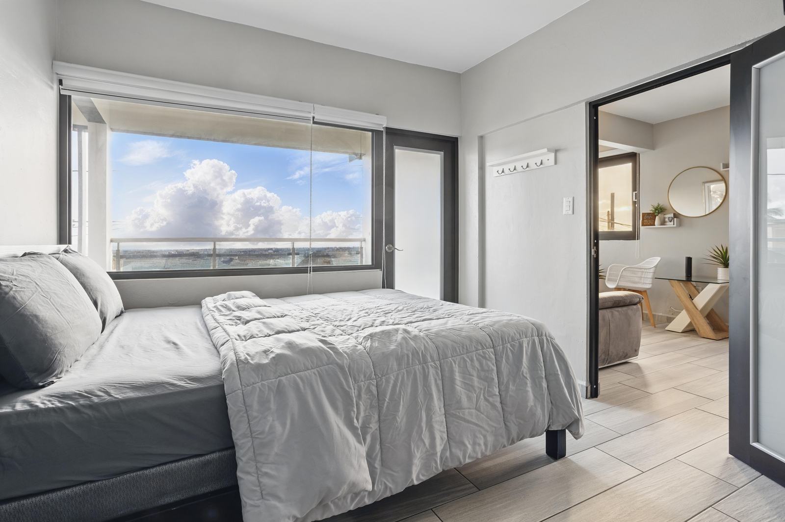 Recámara con cama queen y ventanal con vista